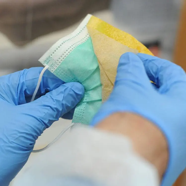 doctor's gloved hands peeling protective film off of a mask for protective sticker | Donate to Support the Technion University | How to Support Israel | American Technion Society