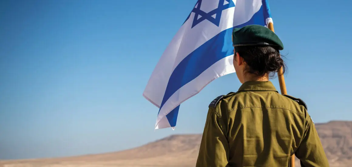 American Technion Society | Women standing with her back to camera holding an Israeli Flag | Israel | Technion | Israeli | IDF