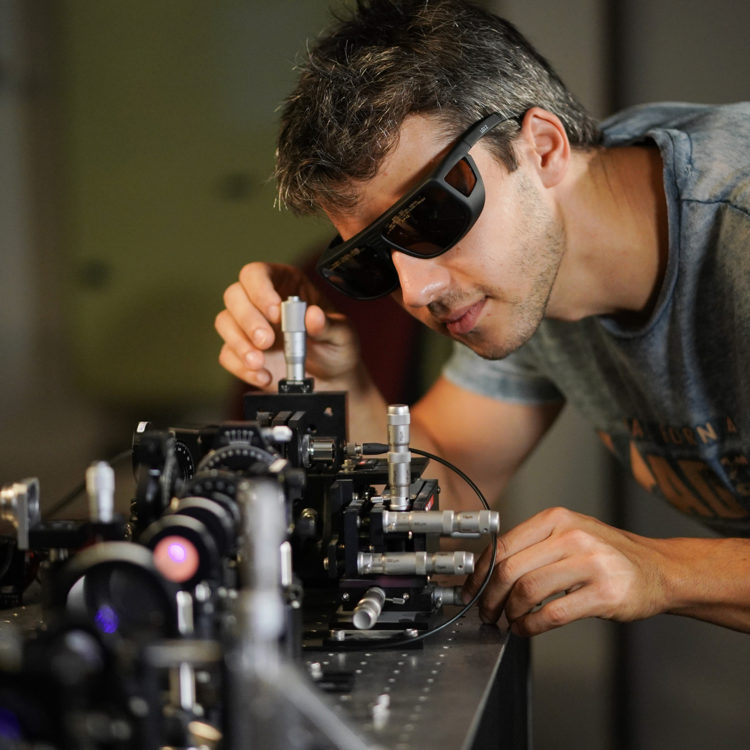Technion researcher working in a quantum lab with a laser machine.