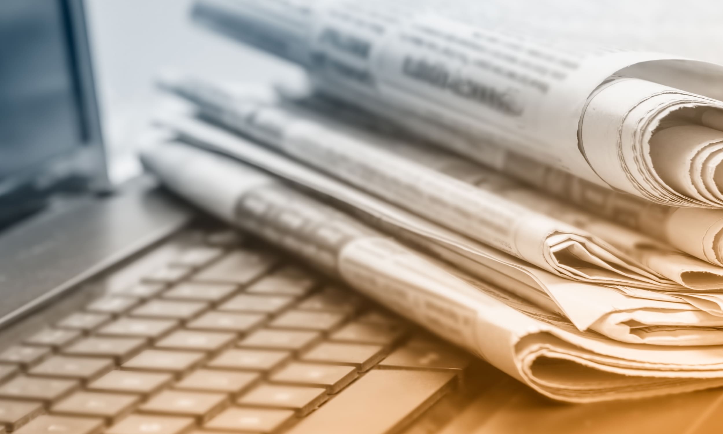 Newspapers laying on a laptop keyboard | Learn how to support Israel and donate to Technion | Israel | American Technion Society