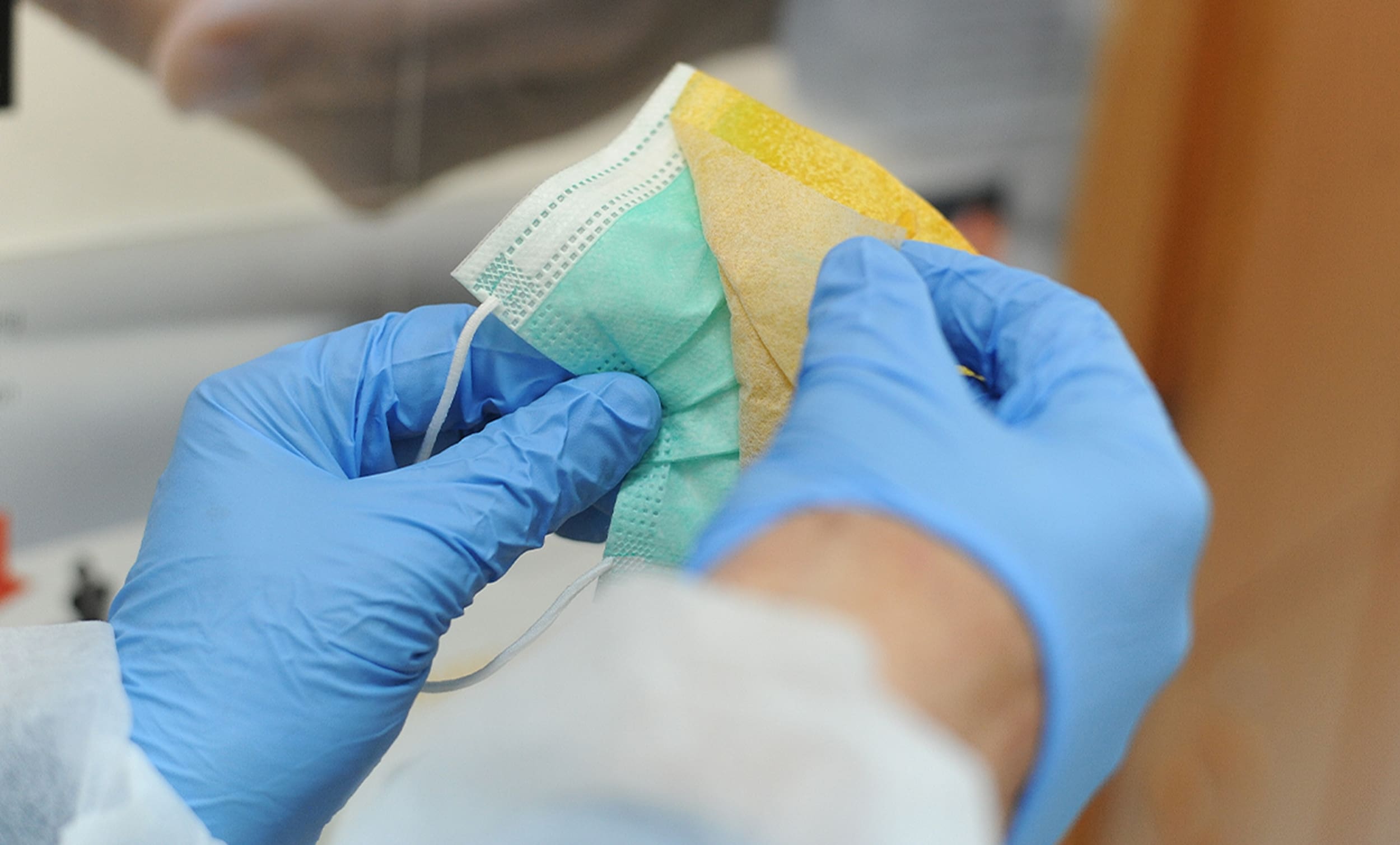 doctor's gloved hands peeling protective film off of a mask for protective sticker | Donate to Support the Technion University | How to Support Israel | American Technion Society