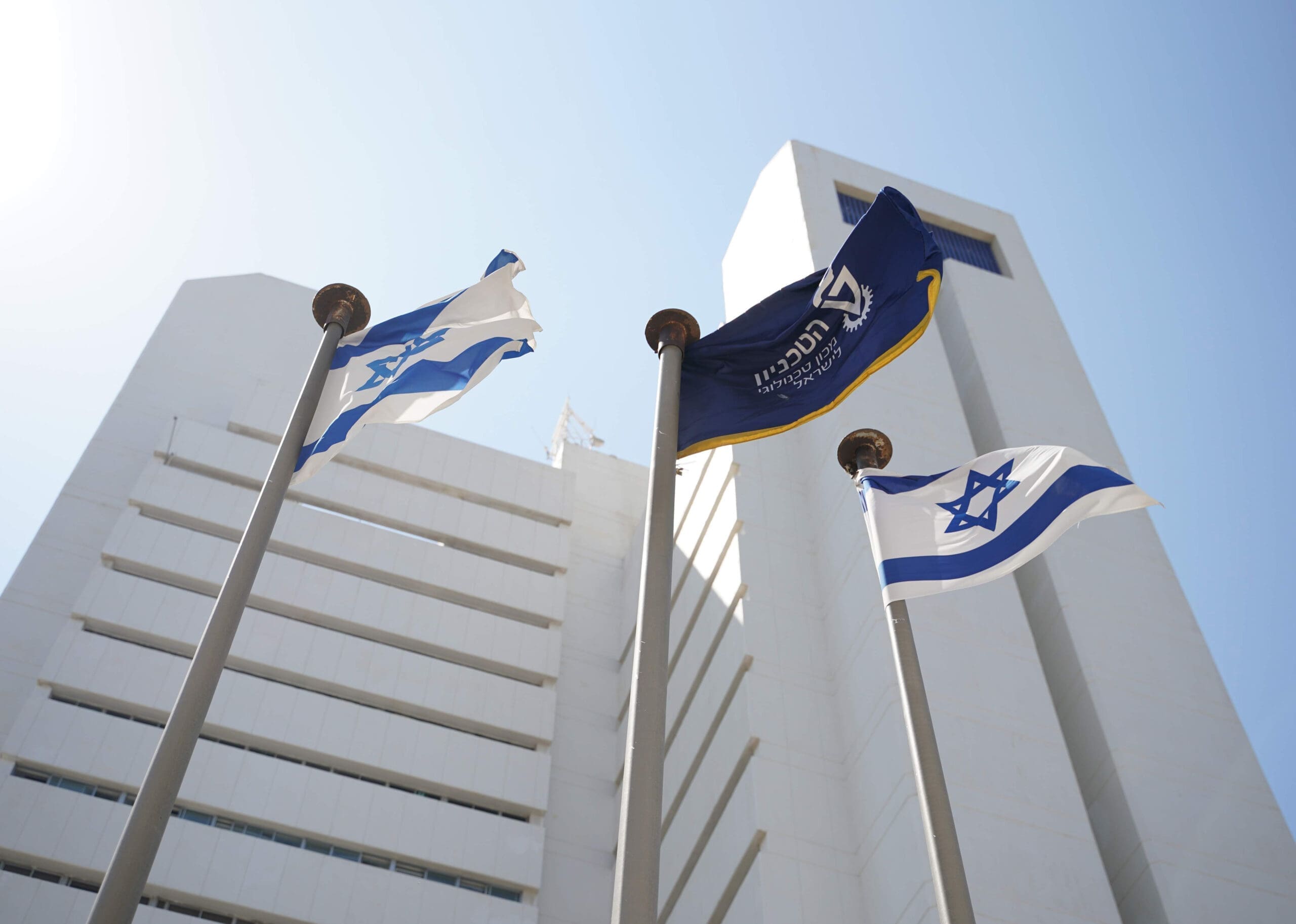 israeli flag and technion flag flying in front of rappaport building in haifa, israel | Donate to Support Israel | Technion University | American Technion Society