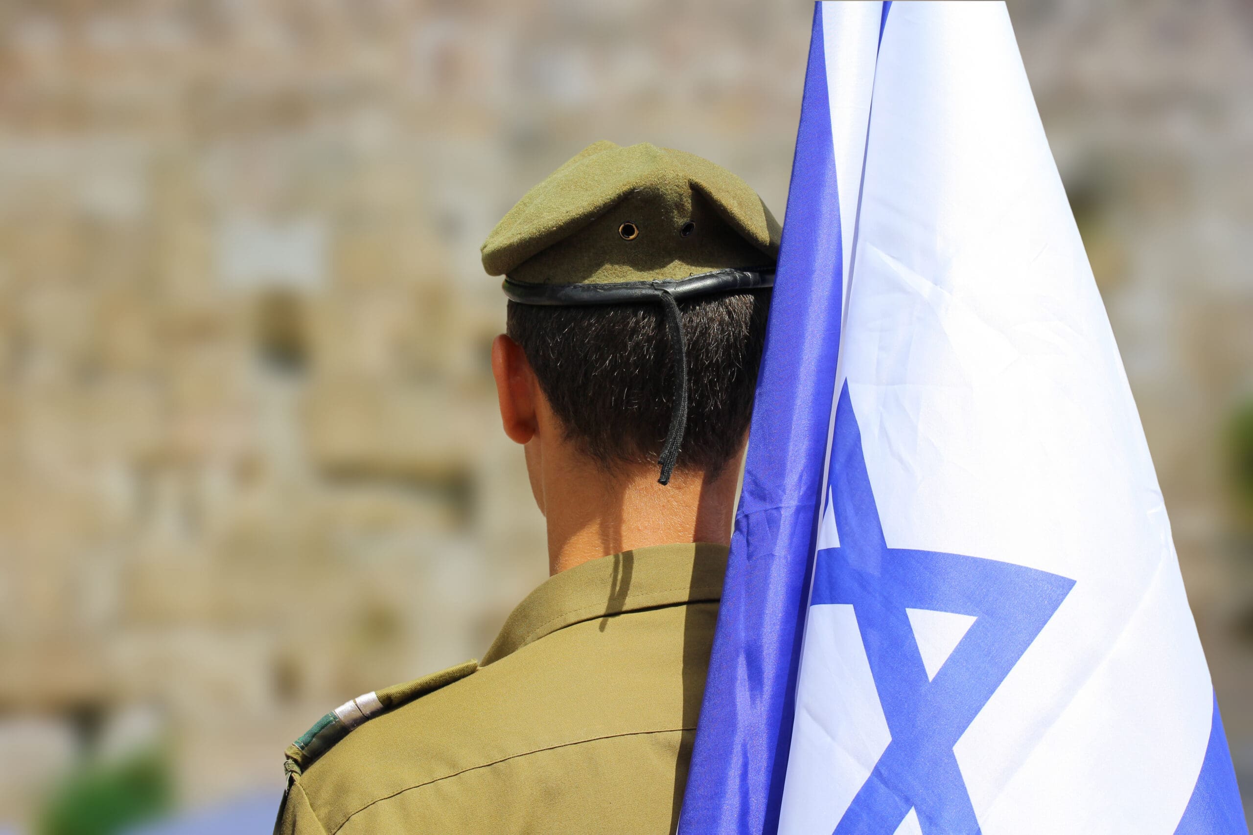 back of the head of an IDF soldier with Israeli flag and blue graphic | managing | Donate to Israel | Technion University