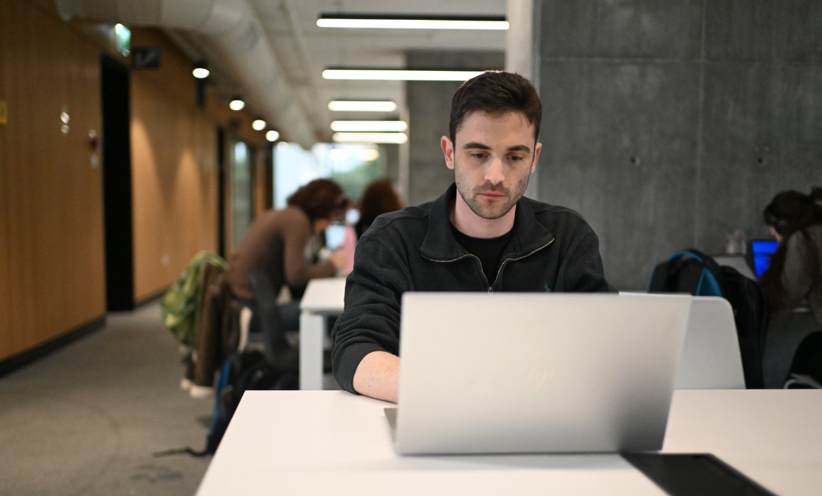 Student working on a laptop in a study area.
