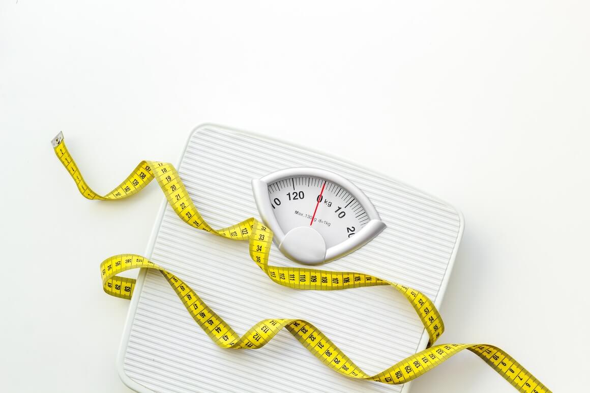 white scale and yellow measuring tape against a white background to lose weight | Donate to Israel | Support the Technion University