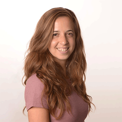 headshot of young woman on white gradient background. long, light brown hair and light purple shirt.