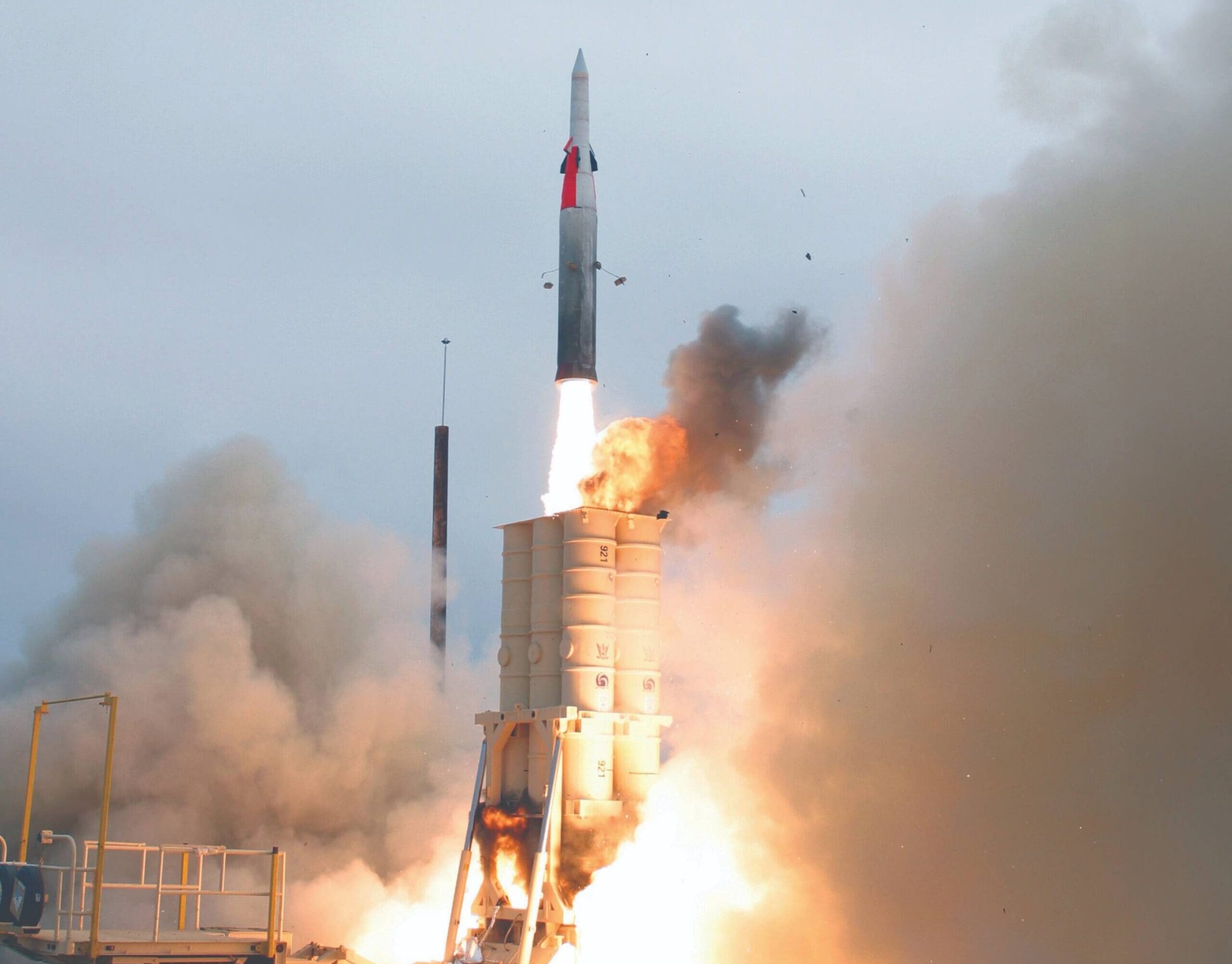 Rocket, mid-launch, with flames and smoke billowing from the engines.