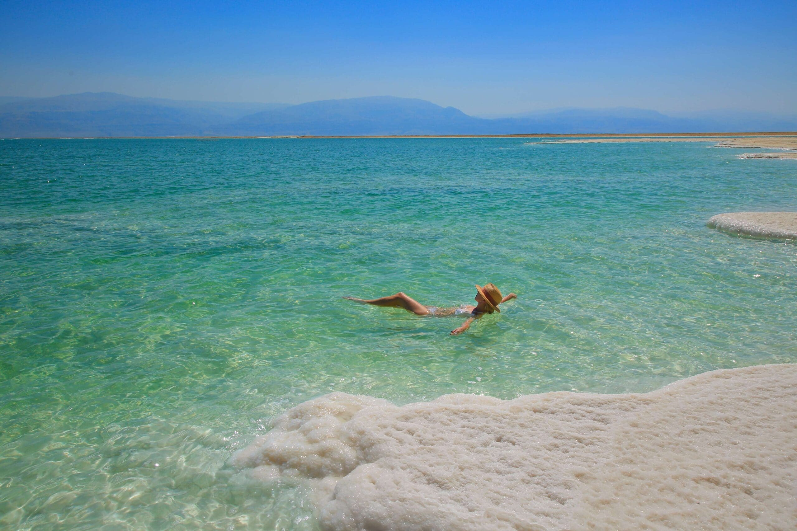 woman floating face up in the Dead Sea.